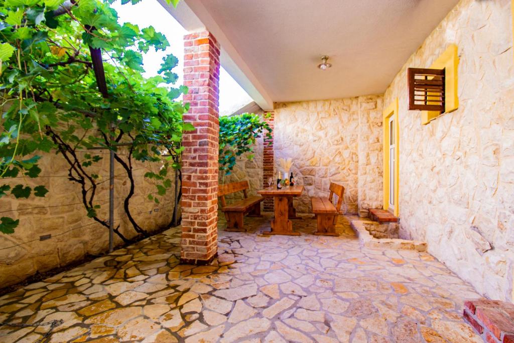 a room with a table and a brick wall at Toncica Sunny terrace with seaview and shaded BBQ area in Metajna