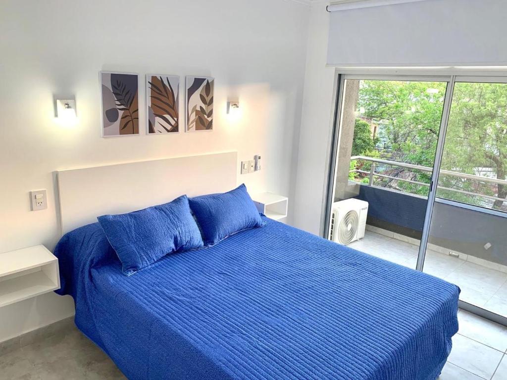 1 dormitorio con cama azul y balcón en Milan Aparts 1 en Colón