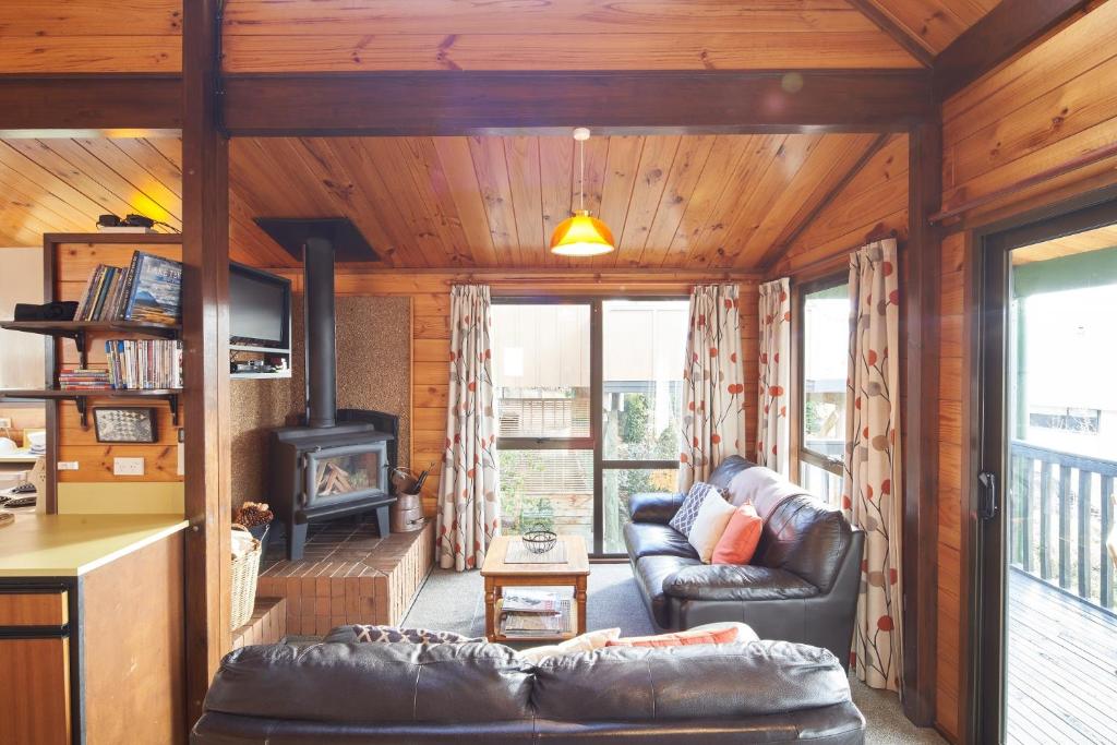a living room with a couch and a stove at Retro Inn 1 - Lake Tekapo in Lake Tekapo