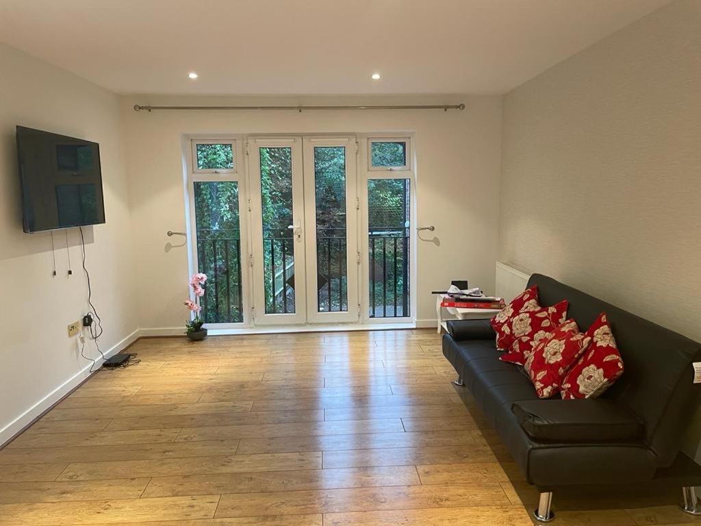 a living room with a couch and a large window at Luxurious & Cosy Apartment in Surrey in Weybridge