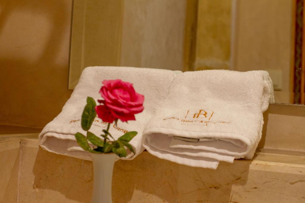 um vaso com uma rosa na frente de uma toalha em Borj Des Cascades & Spa em Ouzoud