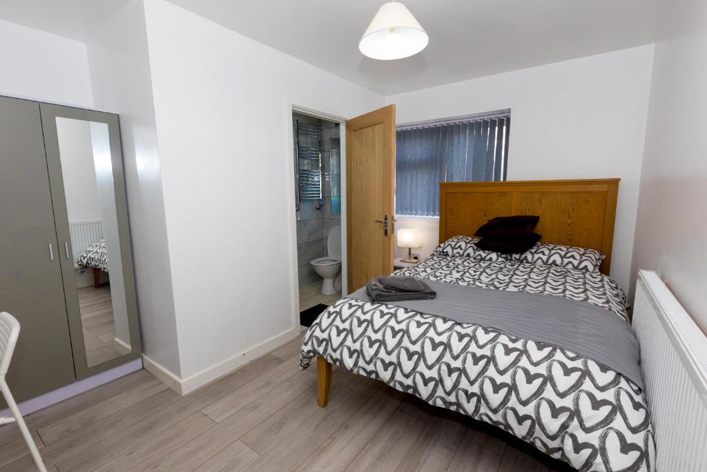 1 dormitorio con 1 cama con edredón blanco y negro en Comfortable stay in Shirley, Solihull - Room 1, en Birmingham