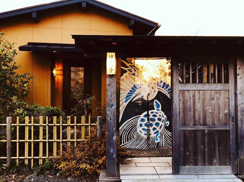 a house with a door with a painting of a peacock at Shimanto River House Yuube-Tei in Shimanto