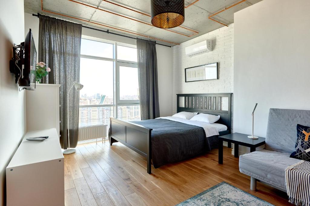 una piccola camera con letto e divano di Стильні апартаменти у центрі міста із казковим краєвидом a Kiev