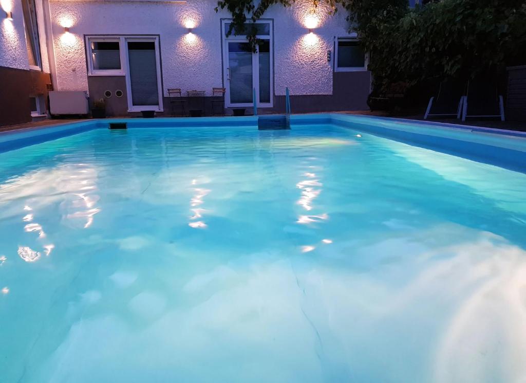 a swimming pool at night with blue water at Grüne Stadtrandidylle - 22 min bis Potsdamer Platz in Berlin