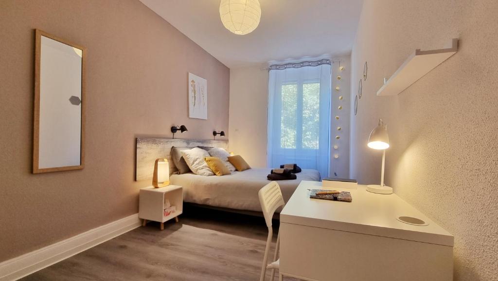 um quarto com uma cama, uma secretária e um espelho em Bulles de sommeil - Cozy - RBNB em Mulhouse