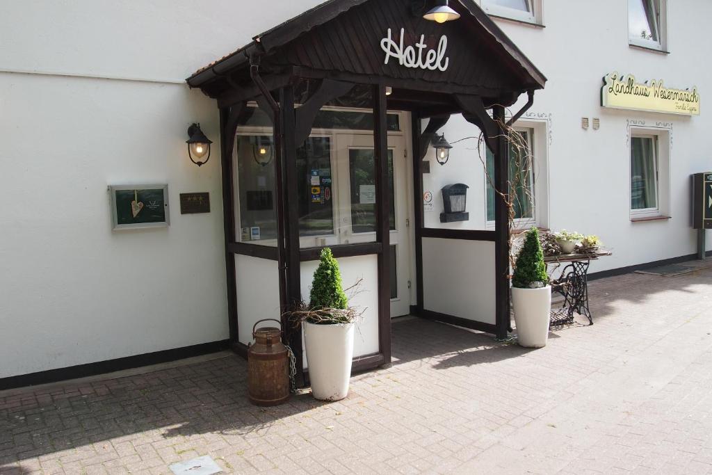 a building with awning with potted plants in front of it at Landhaus Wesermarsch in Achim