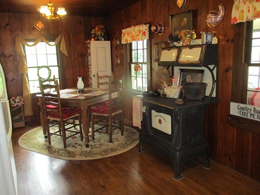 普林斯顿Cabin retreat just off I-77, wonderful experience for 2!的客房设有燃木炉、桌子和椅子。