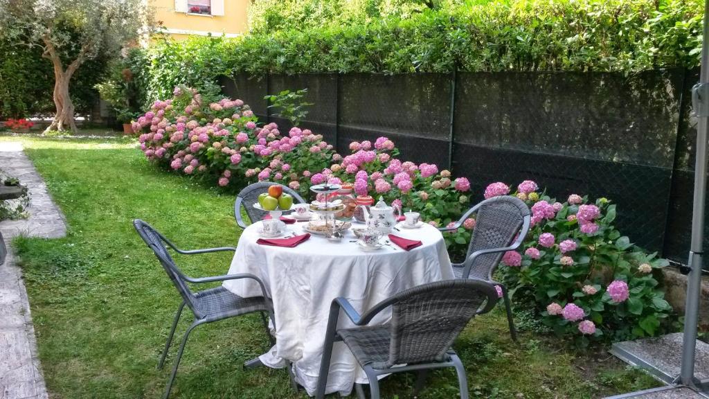 une table dans un jardin avec des chaises et des fleurs dans l'établissement Bed & Breakfast Agli Aceri, à Vérone