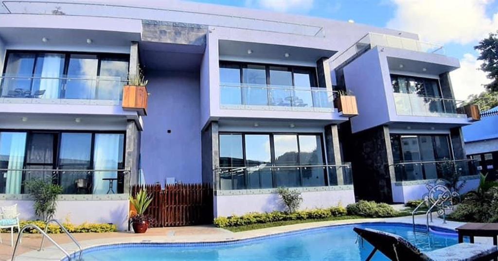 a house with a swimming pool in front of it at One Rodney Heights Condominiums in Gros Islet