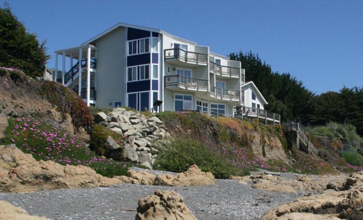 a large building on top of a hill with flowers at The Oceanfront Inn in Shelter Cove