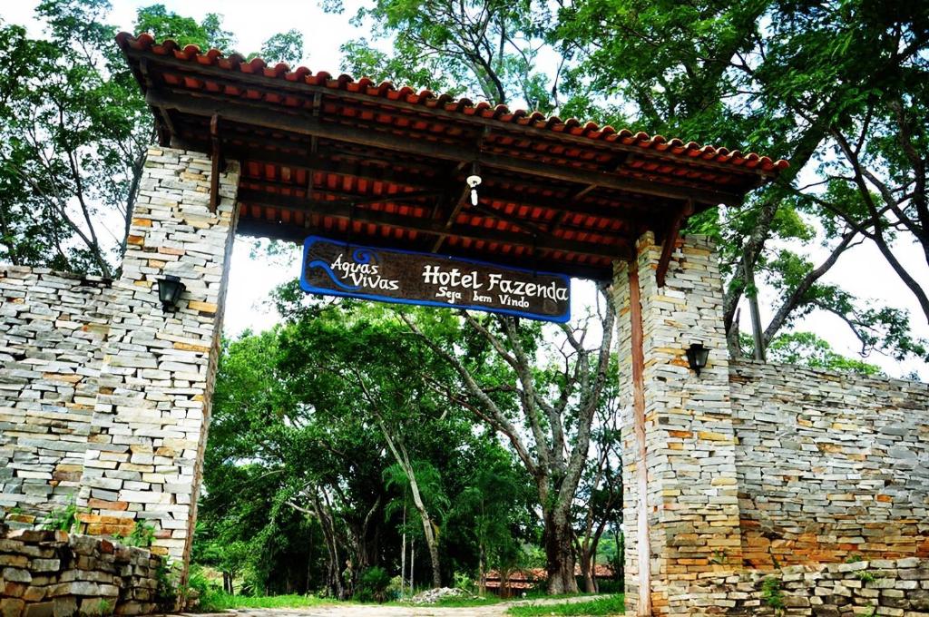 ein Schild an einer Backsteinmauer mit einem Straßenschild in der Unterkunft Águas Vivas Hotel Fazenda in Pirenópolis
