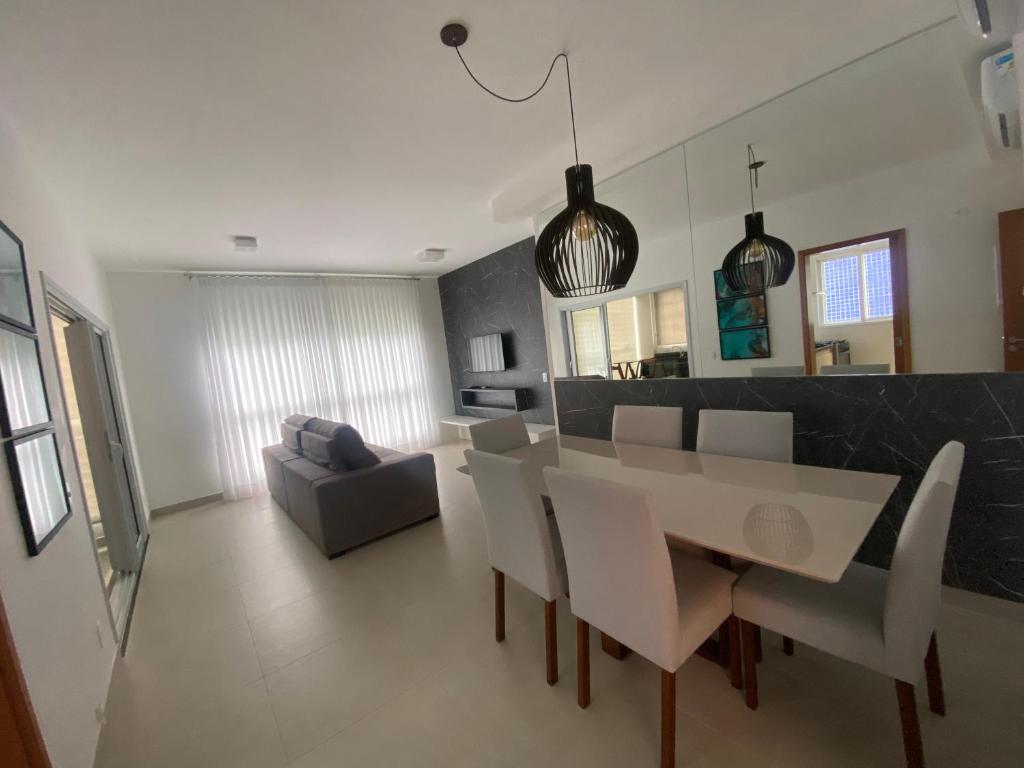 comedor y sala de estar con mesa y sillas en Apartamento Praia Grande, en Ubatuba