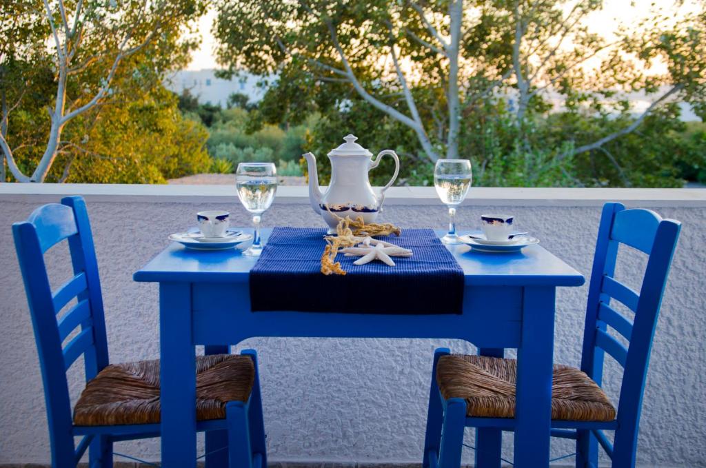 una mesa azul con gafas y un jarrón en ella en Helen's Budget Accommodation en Aliki