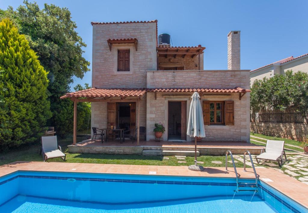 a villa with a swimming pool in front of a house at Villa Phaedra in Prinés