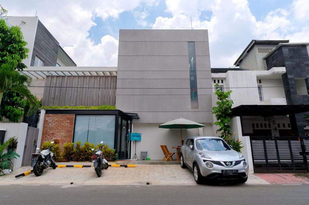 un coche aparcado frente a un edificio en LeGreen Suite Semanggi en Yakarta