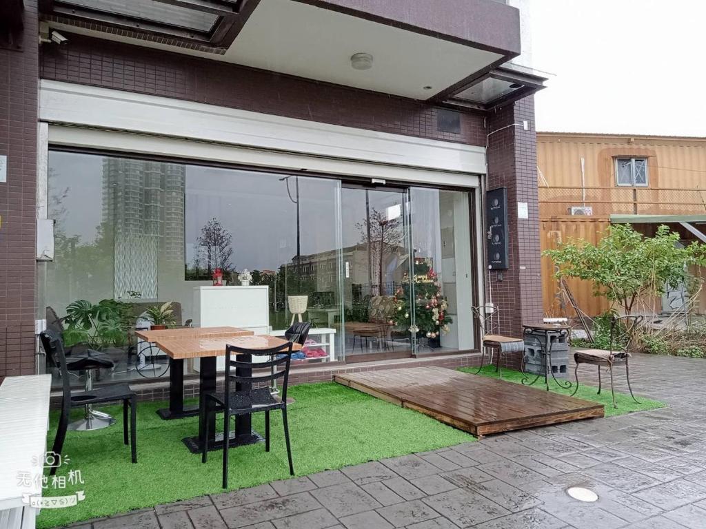 un patio con mesa, sillas y una ventana grande en 宜蘭頭城空空如也Kong Kong, en Toucheng