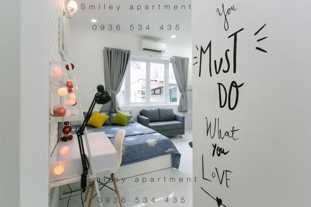 une petite chambre avec un lit et un canapé dans l'établissement Happy Apartment, à Hô-Chi-Minh-Ville
