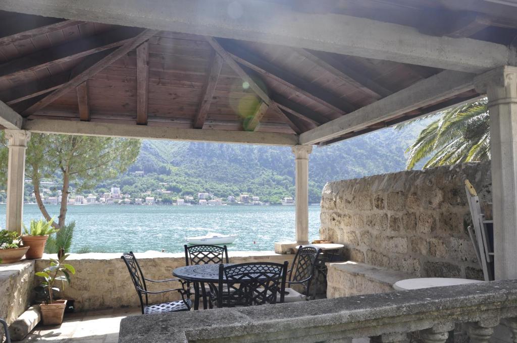 a patio with chairs and a table with a view of the water at Apartments Vujošević in Kotor