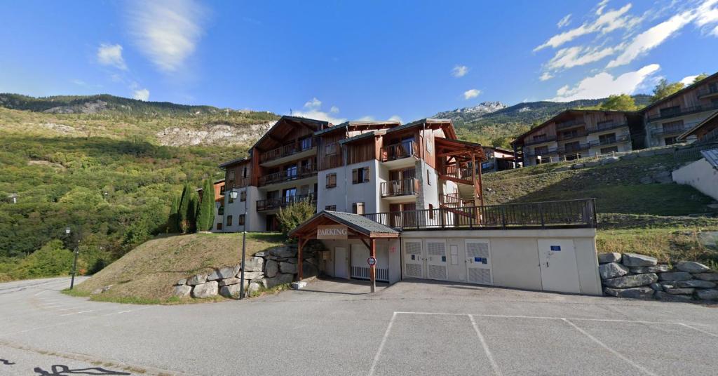 un edificio en una colina con aparcamiento en Appartement Orelle Val-Thorens avec SPA, en Orelle