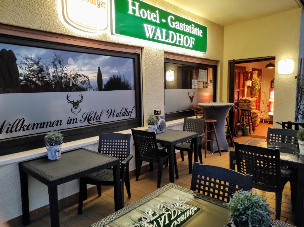 a restaurant with tables and chairs and a sign on the wall at Hotel Pension Waldhof in Simmern