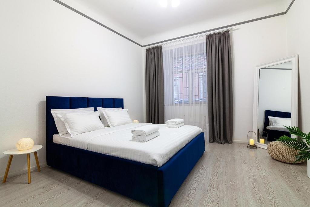 リヴィウにあるAvangard Shevchenko Avenue 11 Apartのベッドルーム(青と白のベッド、鏡付)