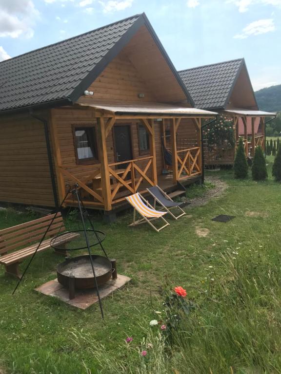 Cabaña de madera con parrilla en el patio en Domki Złota Rybka nad Jeziorem- Jacuzzi, en Zawóz