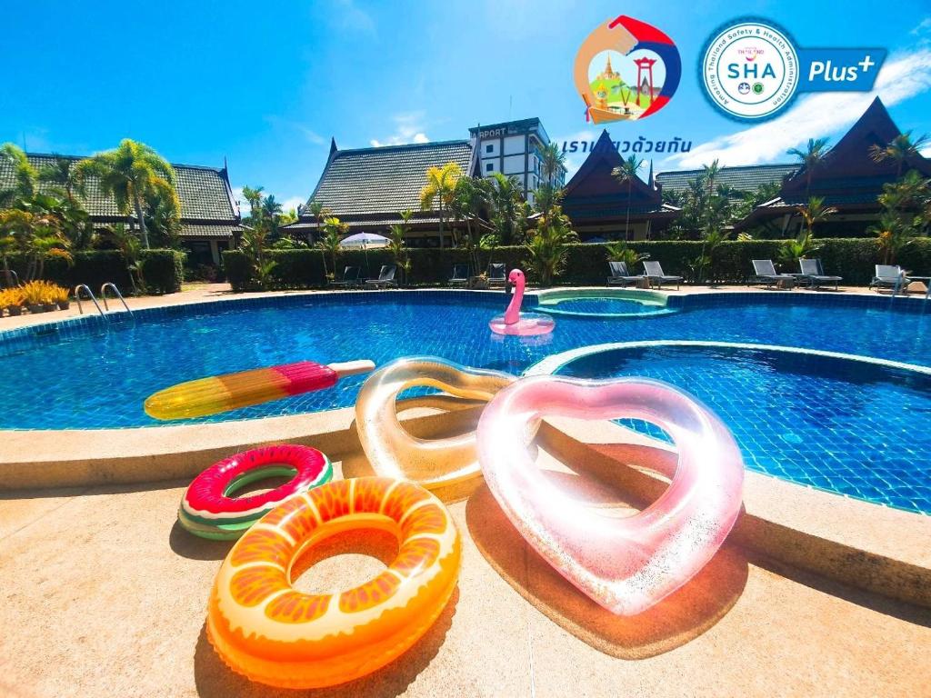 een zwembad met meerdere opblaasbare bedden op de grond naast een zwembad bij Airport Resort Phuket in Nai Yang Beach