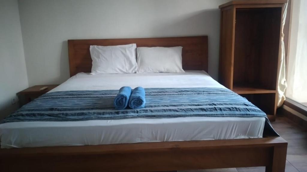 un par de zapatos azules sentados en una cama en Kutabay Homestay, en Kuta Lombok