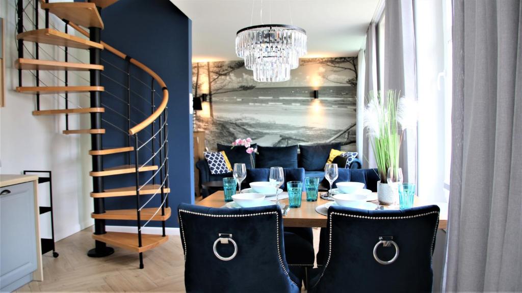 a dining room with a table with chairs and a chandelier at Apartamenty Royal Maris 2 - najlepsza lokalizacja w Ustce, blisko plaży i portu, bezpłatny parking, ścicsłe centrum in Ustka
