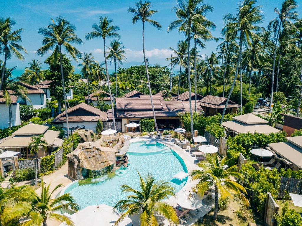 a beach with palm trees and palm trees at Khwan Beach Resort - Luxury Glamping and Pool Villas Samui - Adults Only - SHA Extra Plus in Mae Nam