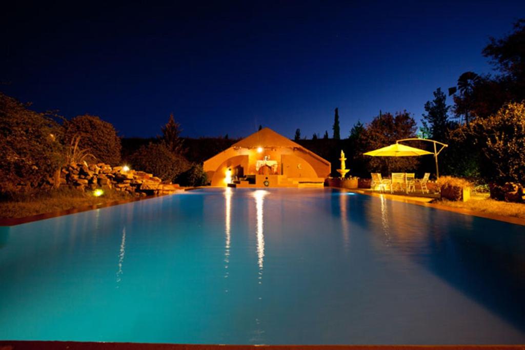 ein großer Swimmingpool in der Nacht mit einem Gebäude in der Unterkunft La Pilar Petit Chalets in San Rafael