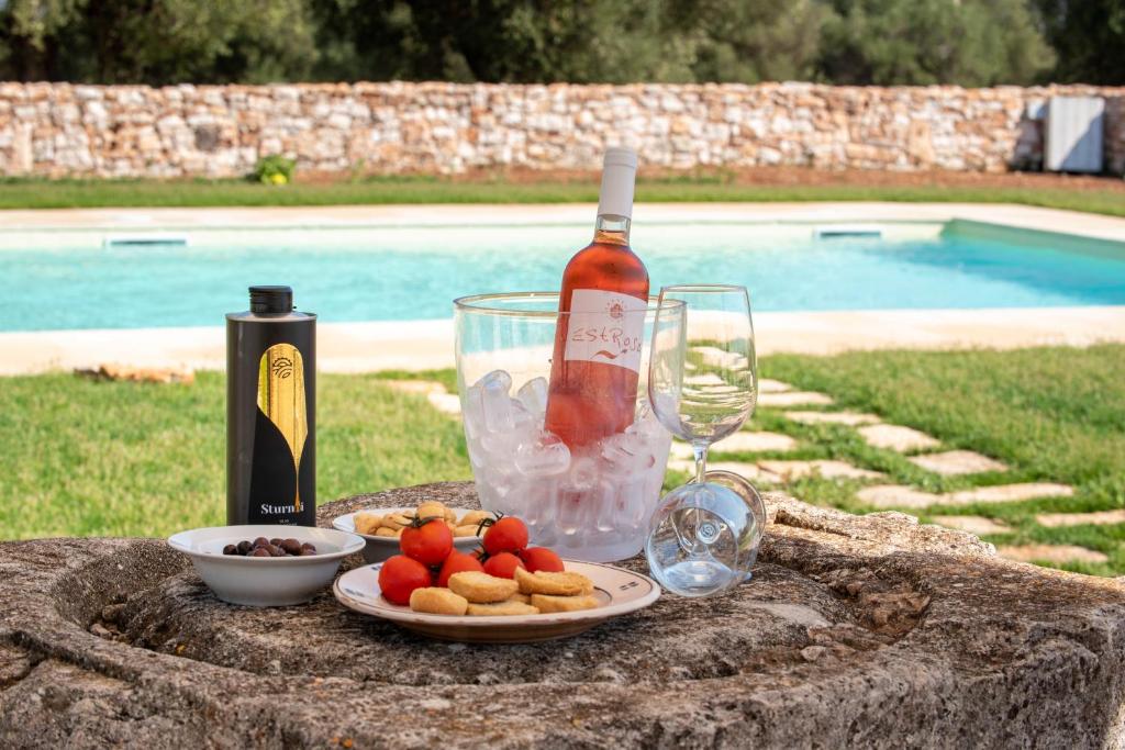 a table with a bottle of wine and a plate of food at Masseria Borgo Santuri in Ostuni