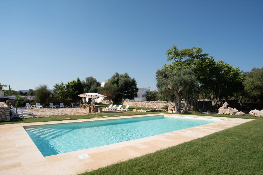 a swimming pool in the middle of a yard at Masseria Borgo Santuri in Ostuni