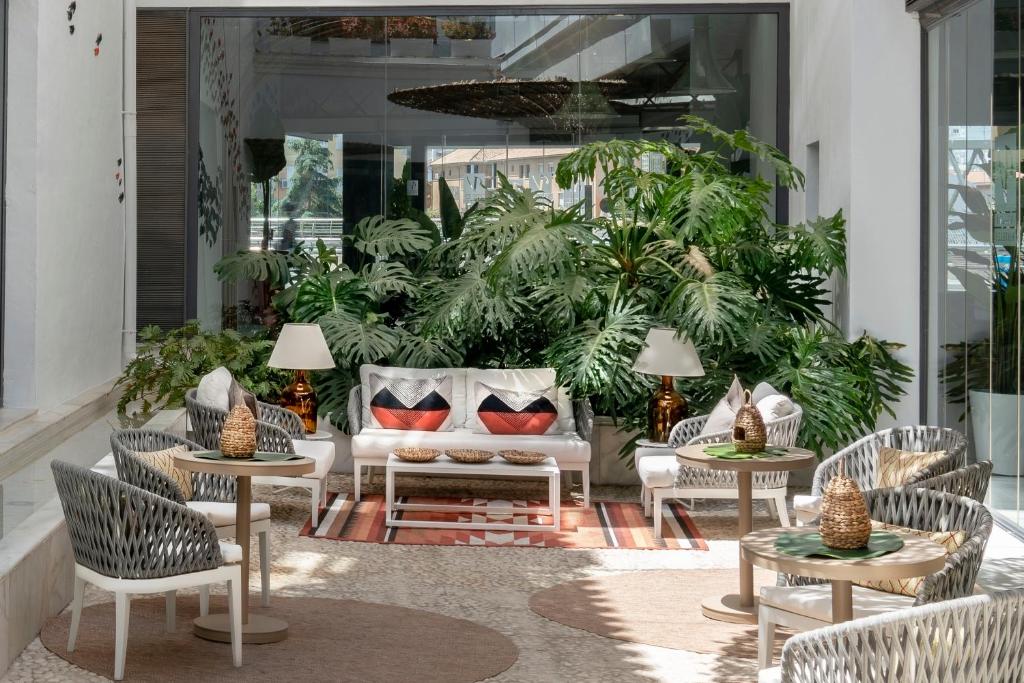 d'une terrasse avec des chaises, des tables et un canapé. dans l'établissement Vincci Selección Posada del Patio, à Malaga