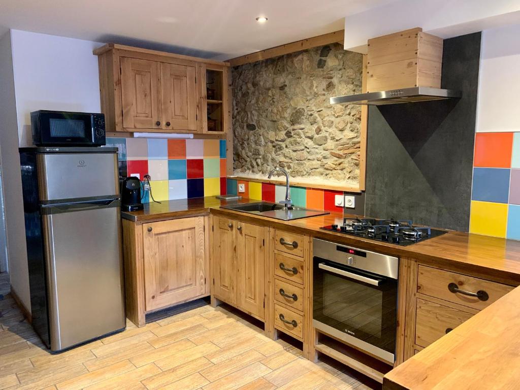 a kitchen with wooden cabinets and a stainless steel refrigerator at Annecy Sainte Claire proche Gare-Lac Duplex 4e étage pour 4ou6 personnes climatisation in Annecy