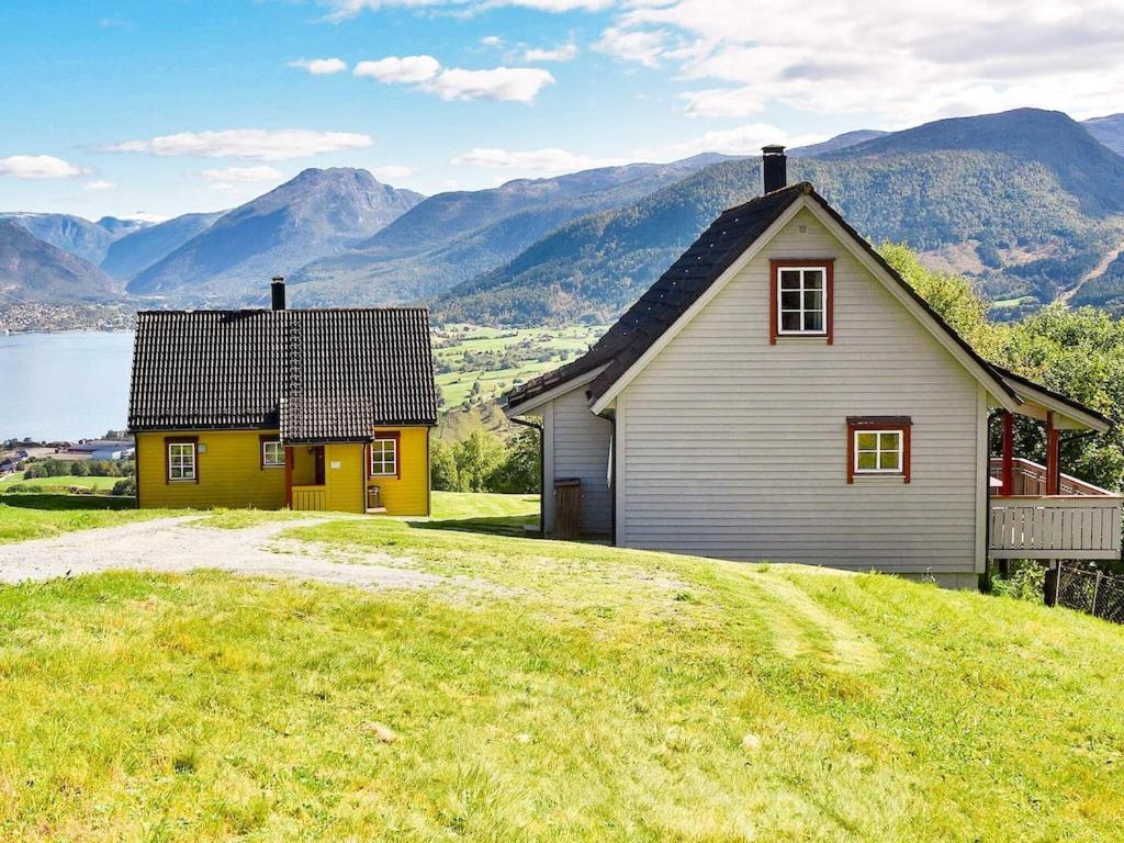 a house on a hill with mountains in the background at Holiday home SANDANE in Sandane