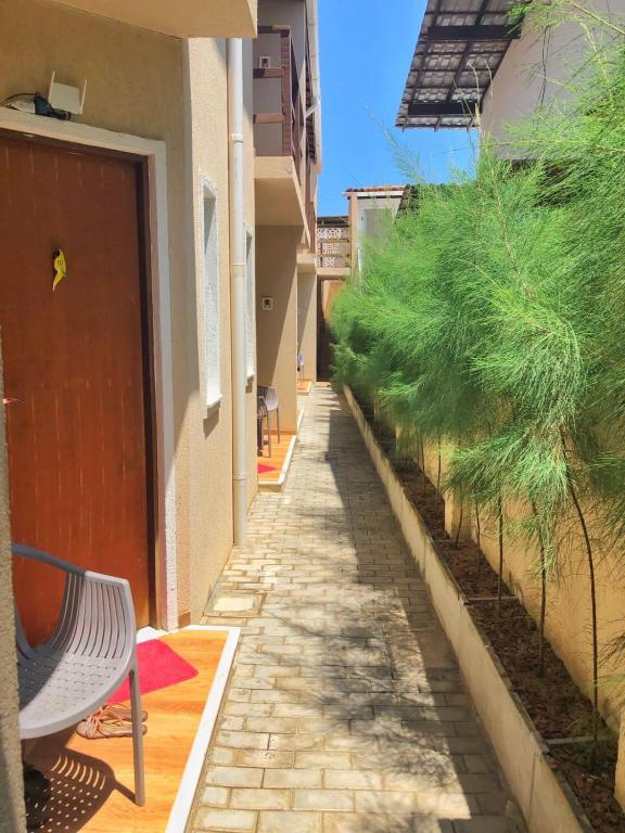 an empty alley with a bench next to a building at Corvina Suites in Praia do Forte
