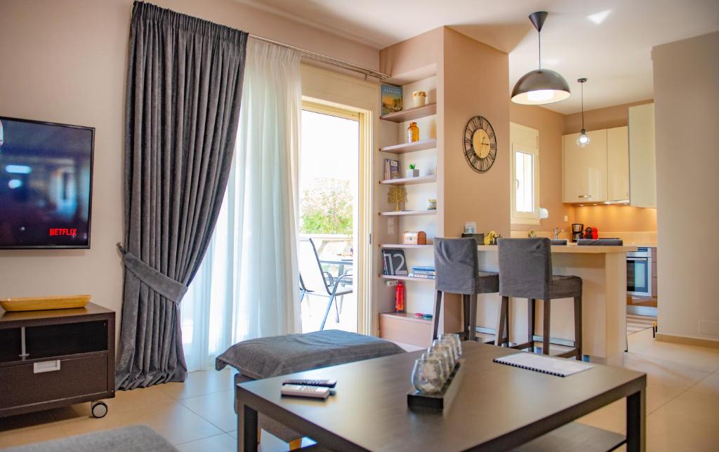 a living room with a couch and a table and a kitchen at S.V. Luxury Apartment in Heraklio