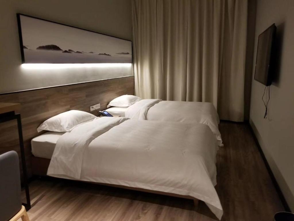 Postel nebo postele na pokoji v ubytování Unijoy Cityinn OCT Loft Shenzhen有集城市客栈创意园店