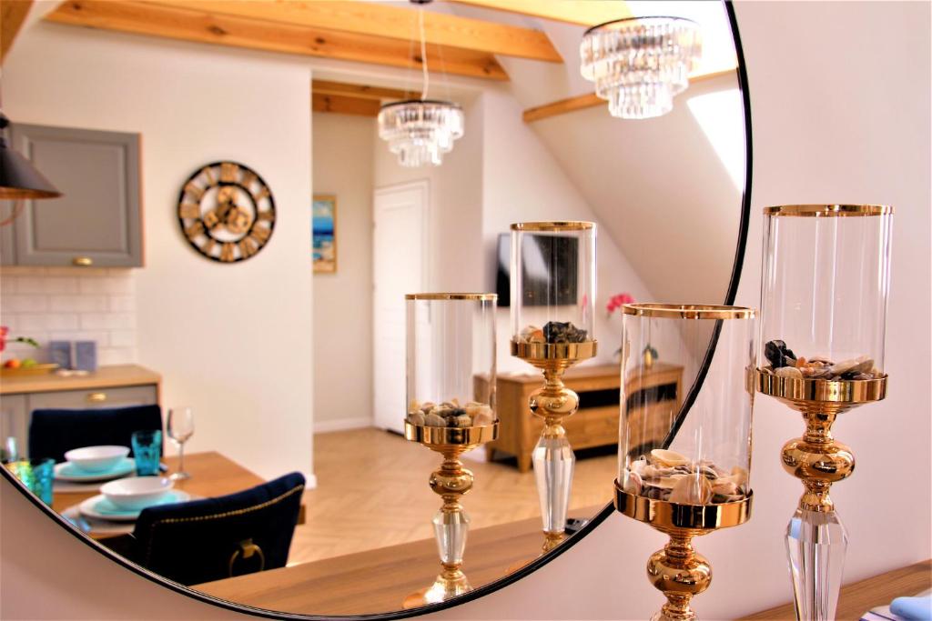 een eetkamer met een spiegel en een eettafel bij Apartamenty Royal Maris 4 - najlepsza lokalizacja w Ustce, blisko plaży i portu, bezpłatny parking, ścicsłe centrum in Ustka