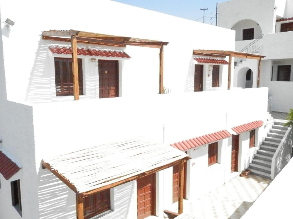 a row of white buildings with red roofs at Aeolos Hotel Apartments in Gythio