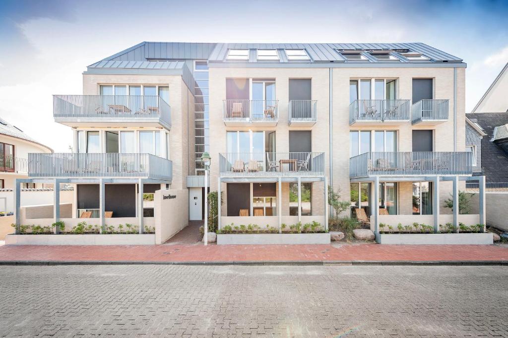 un edificio de apartamentos con balcones y una calle en Inselhouse, en Norderney