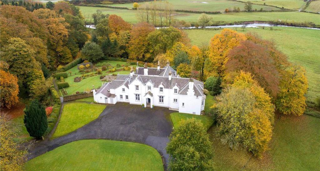 - une vue aérienne sur une grande maison blanche dans l'établissement Park of Drumquhassle, à Glasgow