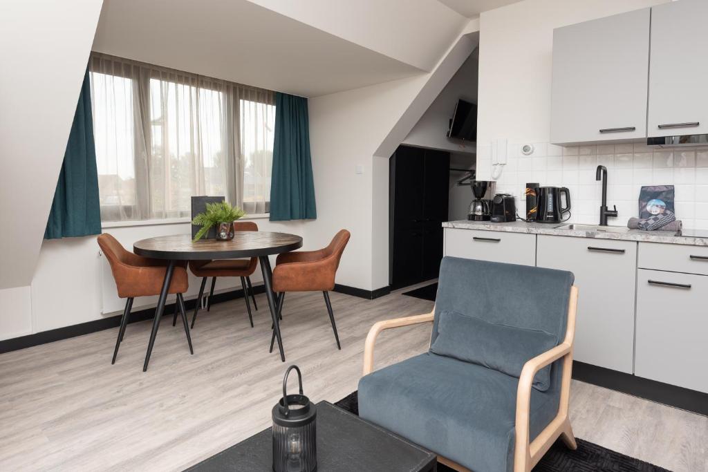 een woonkamer met een tafel en een stoel en een keuken bij Bomont appartementen 2 persoons - Jan van Renesseweg 1 Renesse in Renesse