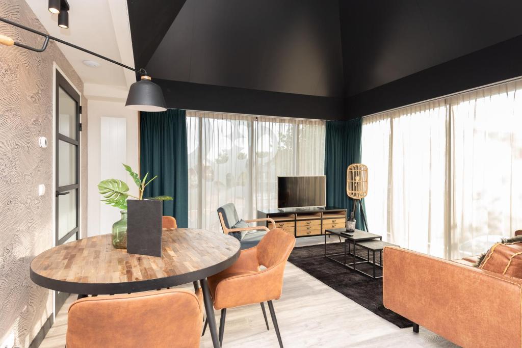 una sala de estar con una mesa y sillas en Welcome in - Bomont appartementen 2 persoons - Jan van Renesseweg 1 Renesse, en Renesse