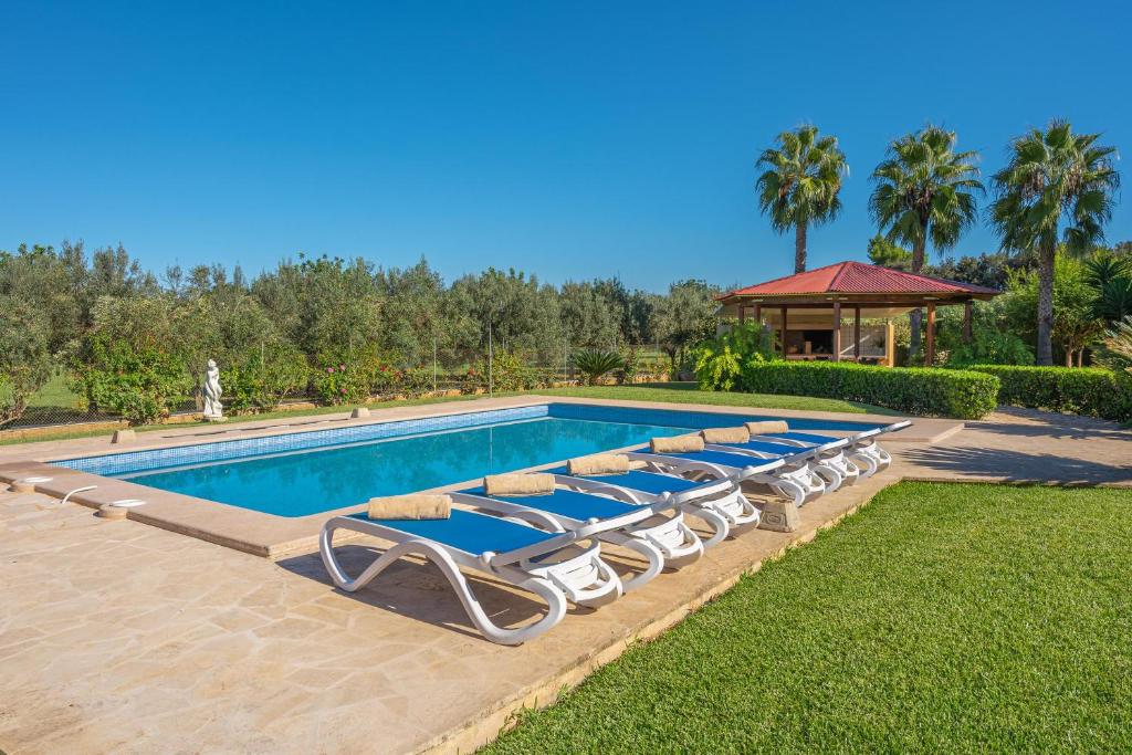 una piscina con tumbonas en un patio en Villa Can Tomeu, en Felanitx