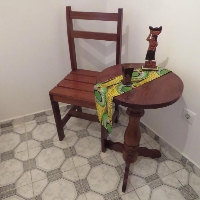 a wooden chair and a table and a wooden chair and a table at Micaval Residential in São Tomé