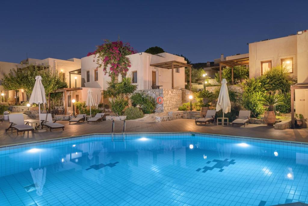 a swimming pool in front of a hotel at night at Ida Village I & II in Hersonissos