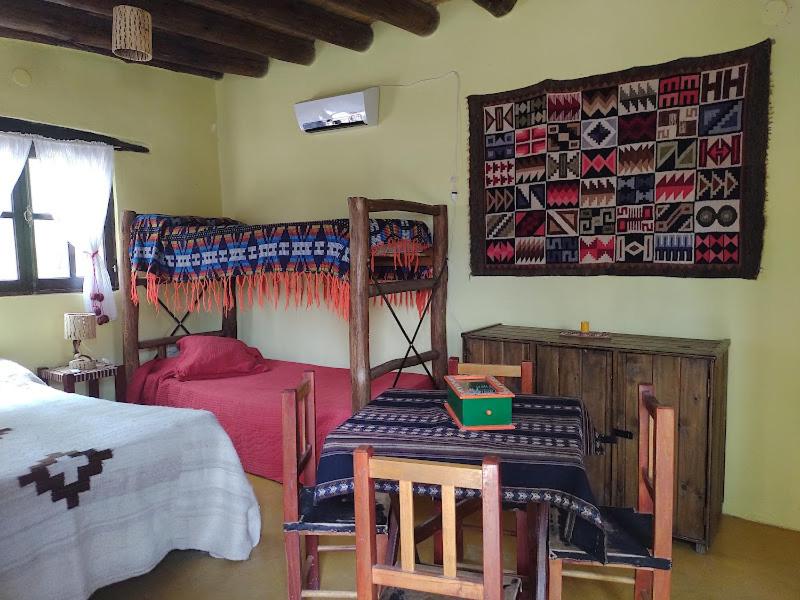a bedroom with a bed and a table and chairs at Los Amarantos in Tilcara